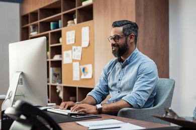Adult sitting at a desk working on computer