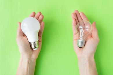 Person holding LED and incandescent lamp