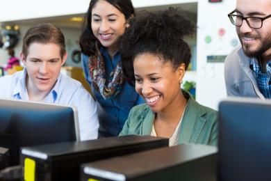 Colleagues around a computer together