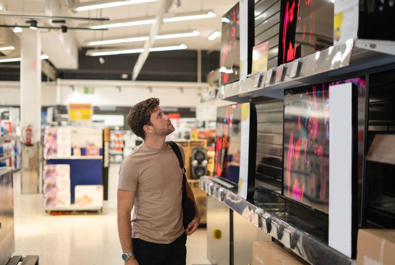 Man choosing TV in retail store