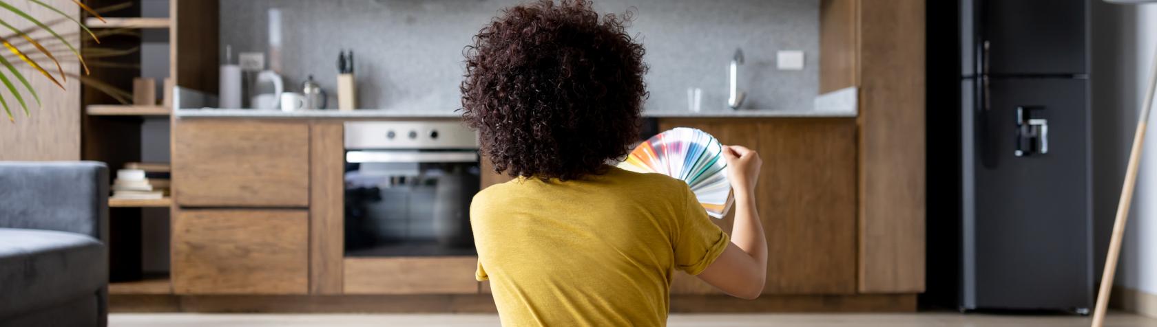 Adult at home choosing a colour to paint the walls